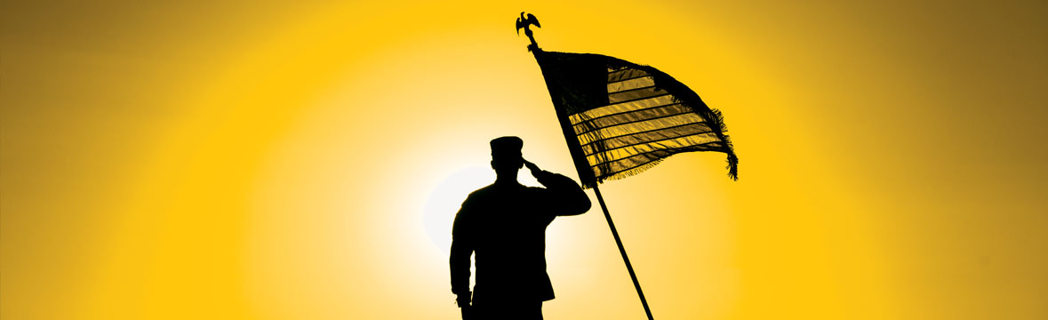 Serviceman saluting U.S. flag.